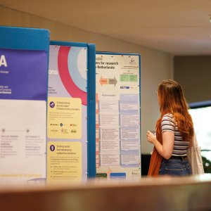 Posters on presentation displays are viewed by a visitor