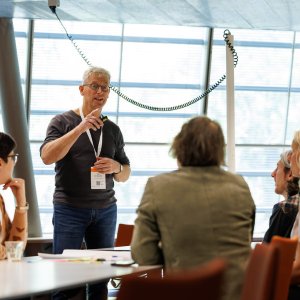 The presenter is in conversation with participants during a workshop.